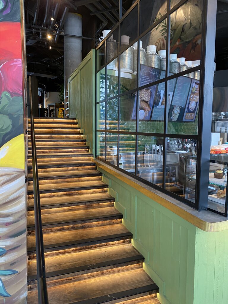 Timber staircase with LED step lighting in a Sydney cafe fitout by Vetra Group